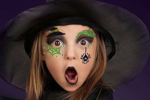 Translation: "Fille déguisée en sorcière avec des autocollants de maquillage.