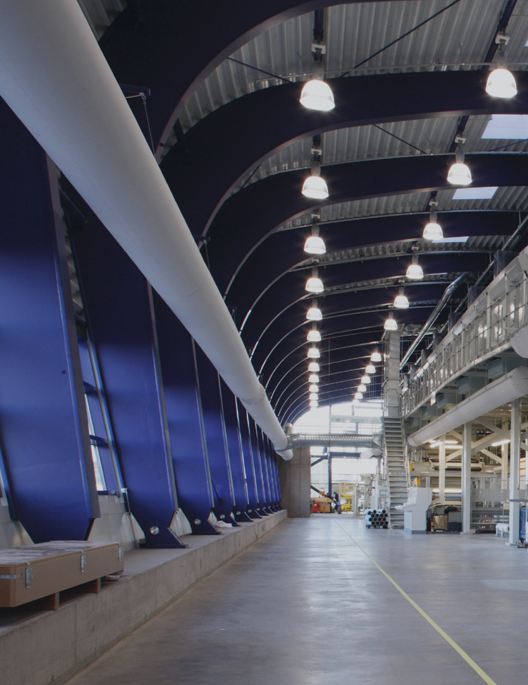 Un intérieur moderne avec de hauts plafonds voûtés, des murs bleus et des plafonniers répartis de manière uniforme.