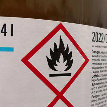 Avertissement sur une étiquette avec un symbole de flamme, indiquant des substances inflammables.