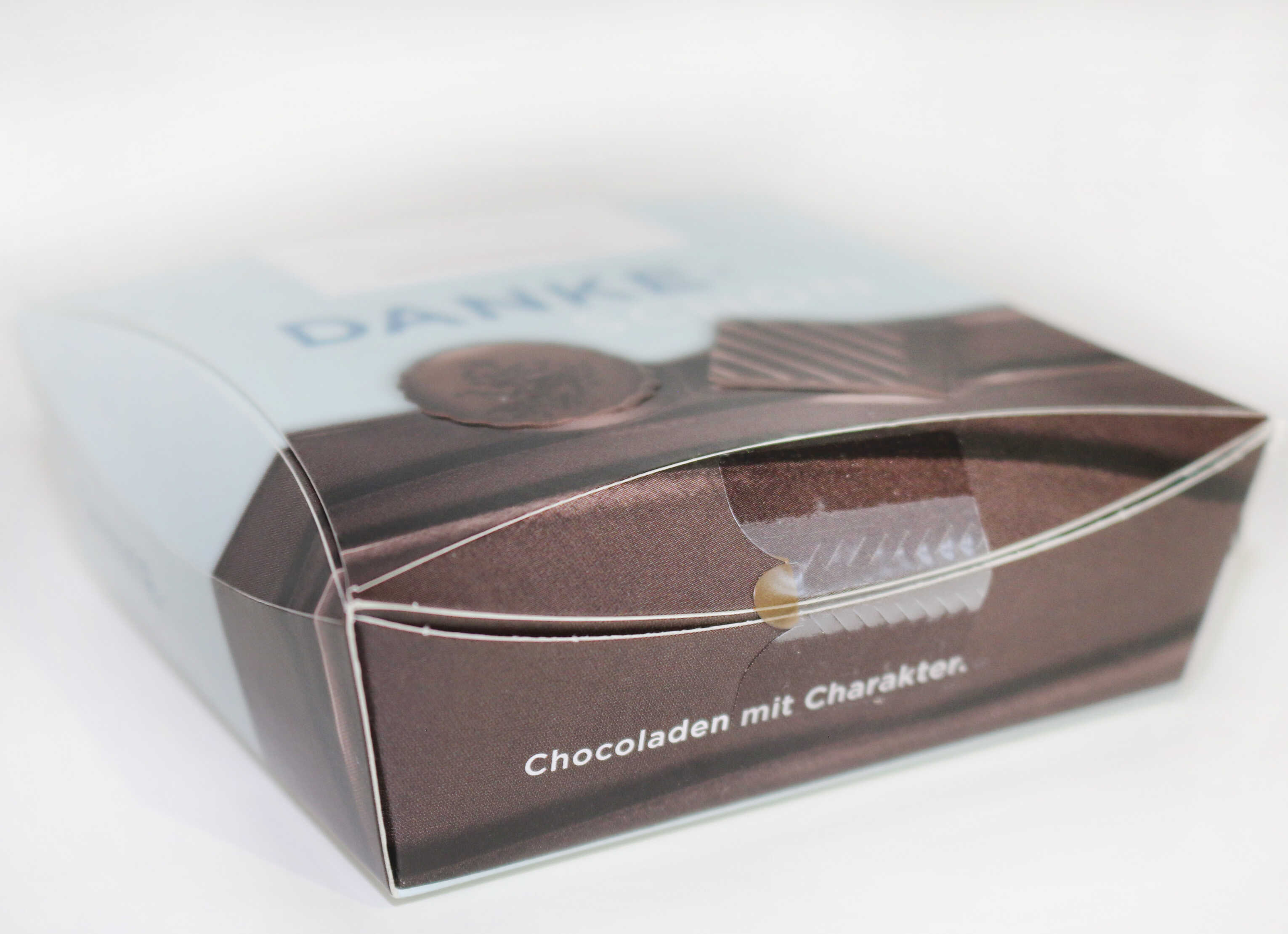 Boîte de chocolat, étiquetée avec "Merci" et le texte "Chocolats avec du caractère.