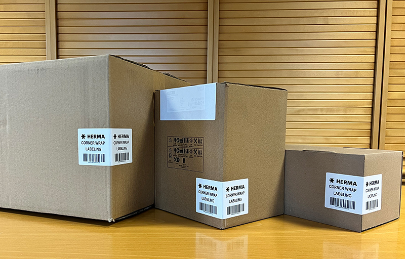 Trois cartons de différentes tailles avec des étiquettes contenant des informations sur le contenu et les détails d'expédition.