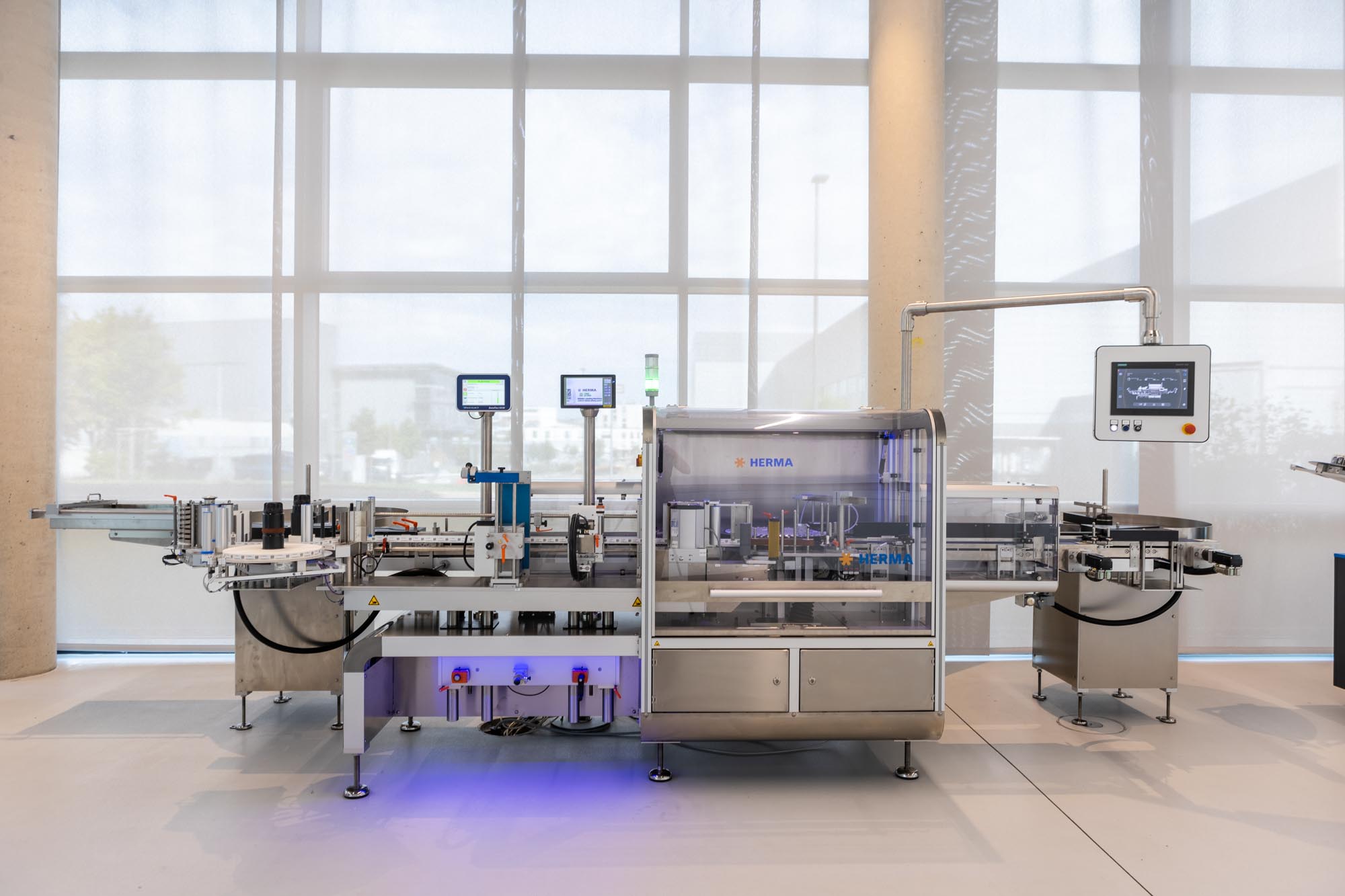 Installation automatique de remplissage et d'étiquetage dans un environnement de production moderne avec plusieurs écrans de surveillance.