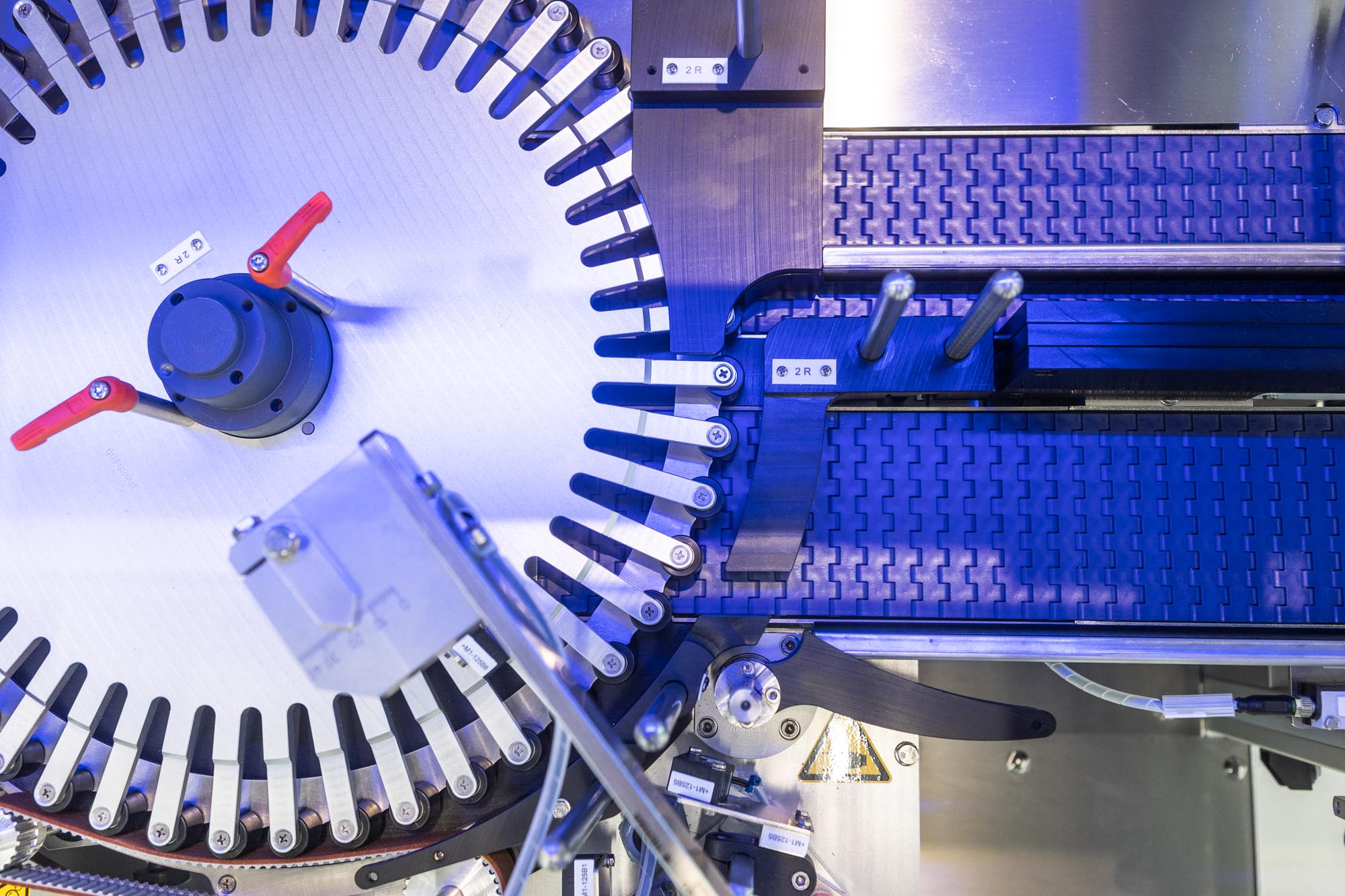 Texte : "Machine avec des pièces rotatives et un convoyeur, utilisée pour des processus industriels. Les composants techniques sont visibles.