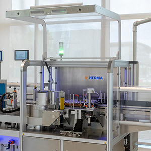 Machine d'étiquetage automatique de HERMA avec différents composants pour l'étiquetage et l'emballage.