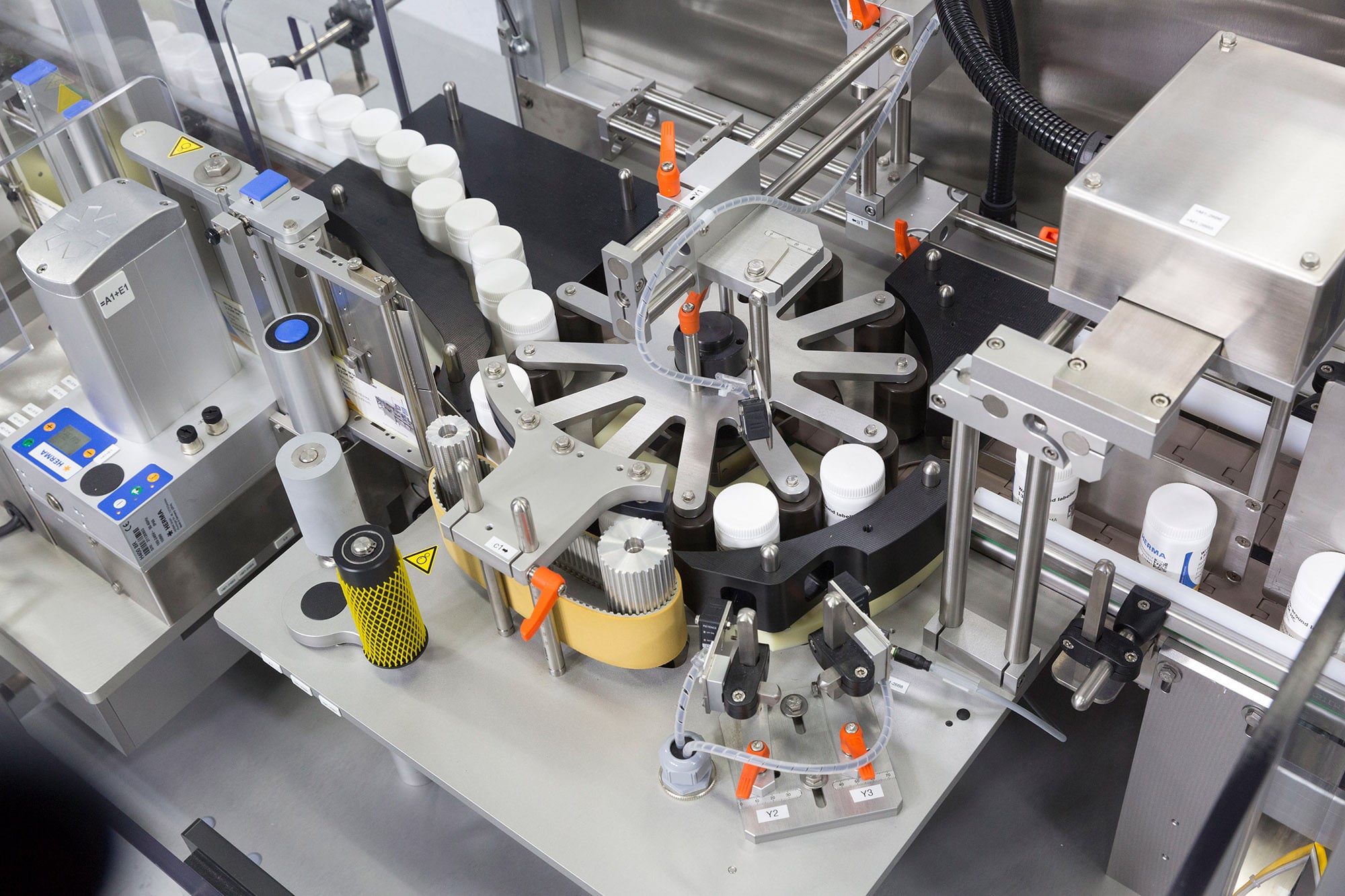 Installation automatisée de remplissage et d'étiquetage avec bouteilles, mécanisme d'étiquetage et divers composants de machines.