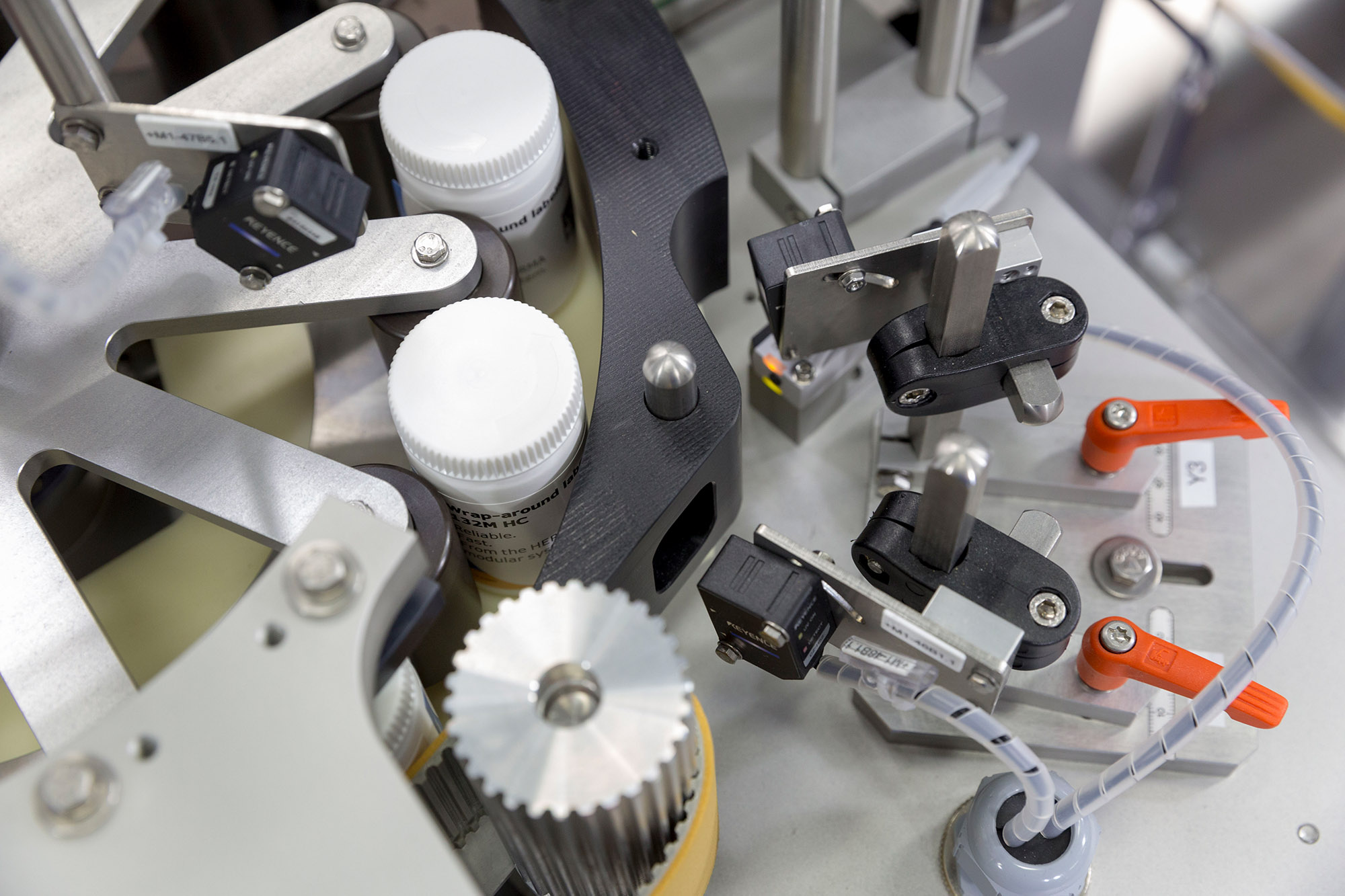 Pièces de machine pour le remplissage de bouteilles, y compris des capteurs et des mécanismes pour contrôler le processus.