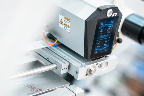 Un panneau de commande précis d'une machine avec des affichages numériques pour la température et la pression, monté sur une structure en métal.