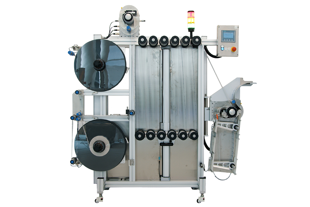 Machine de traitement de films avec deux grands rouleaux, unité de contrôle et trappe de sortie sur le côté droit.