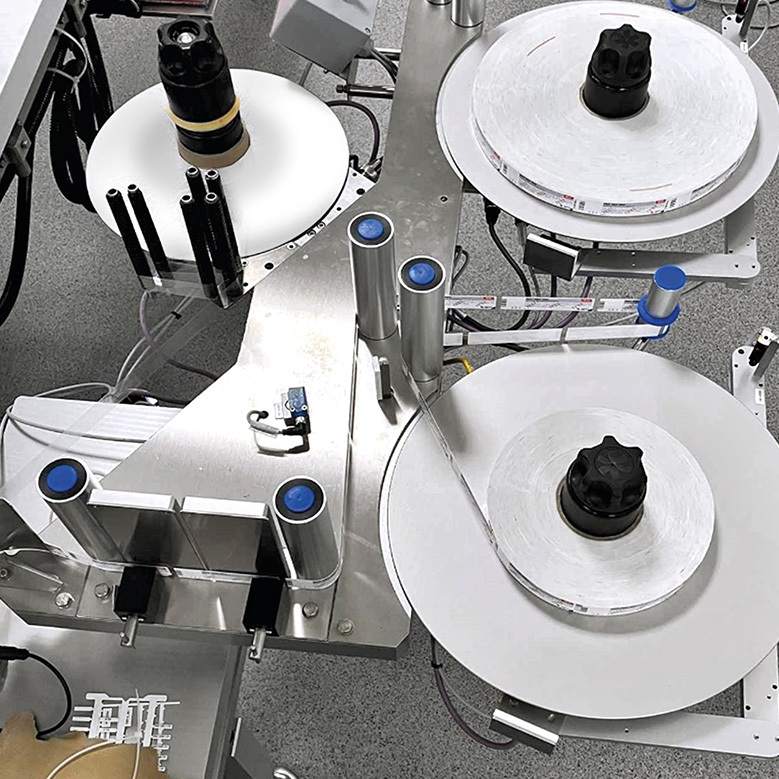 Machine avec plusieurs bobines et rouleaux, utilisée pour le traitement ou l'emballage de matériaux.