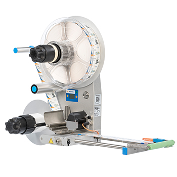 Machine à étiqueter avec support à rouleaux et étiquetage automatique, équipée d'éléments de commande et d'un convoyeur.