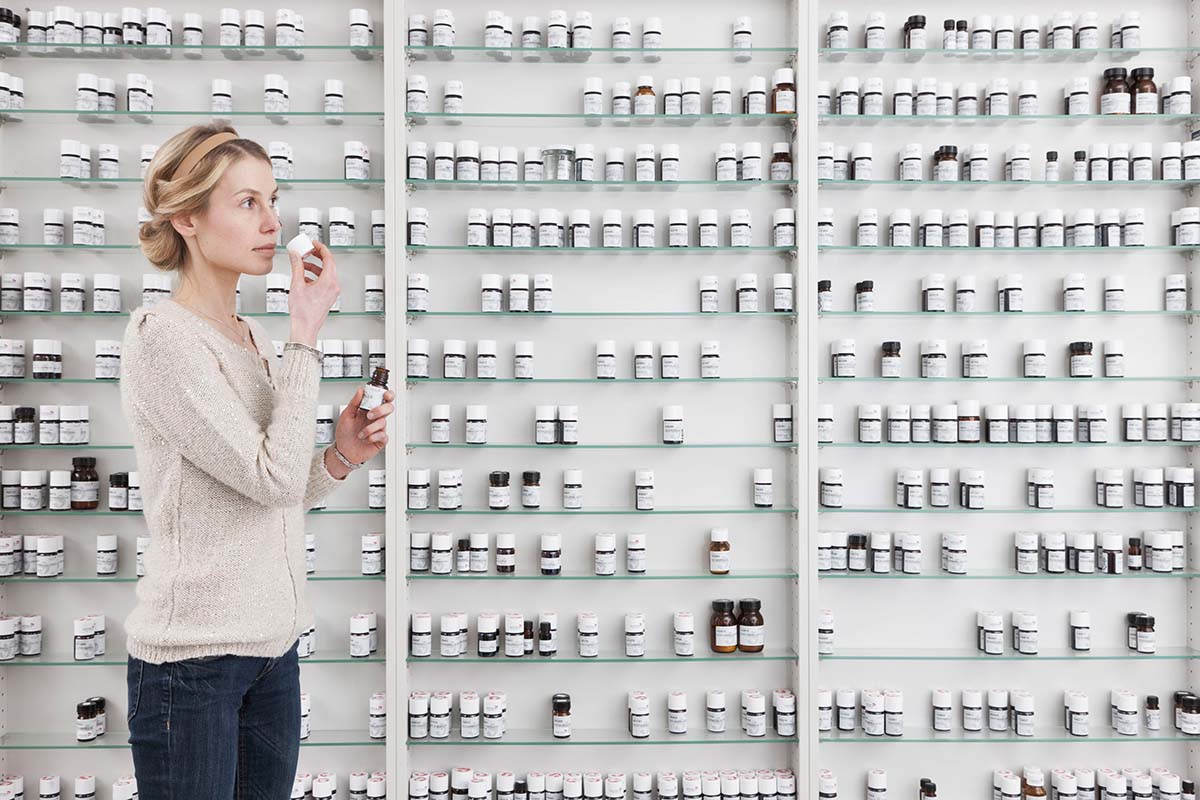 Femme devant une étagère de parfums artificiels
