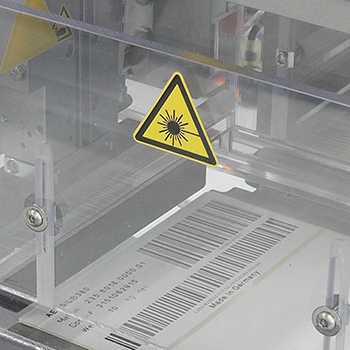 Étiquettes activables par laser avec code-barres dans le processus de production, gros plan de l'unité d'impression laser CO2.