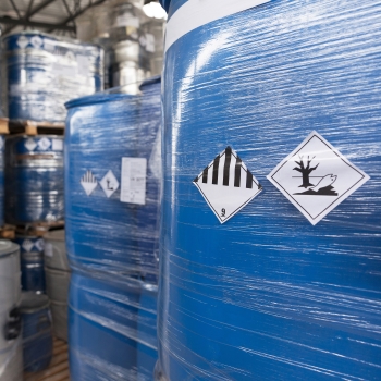 Étiquettes de substances dangereuses et de marchandises dangereuses : Étiquettes de marchandises dangereuses sur des conteneurs shrinkés dans le secteur chimique.