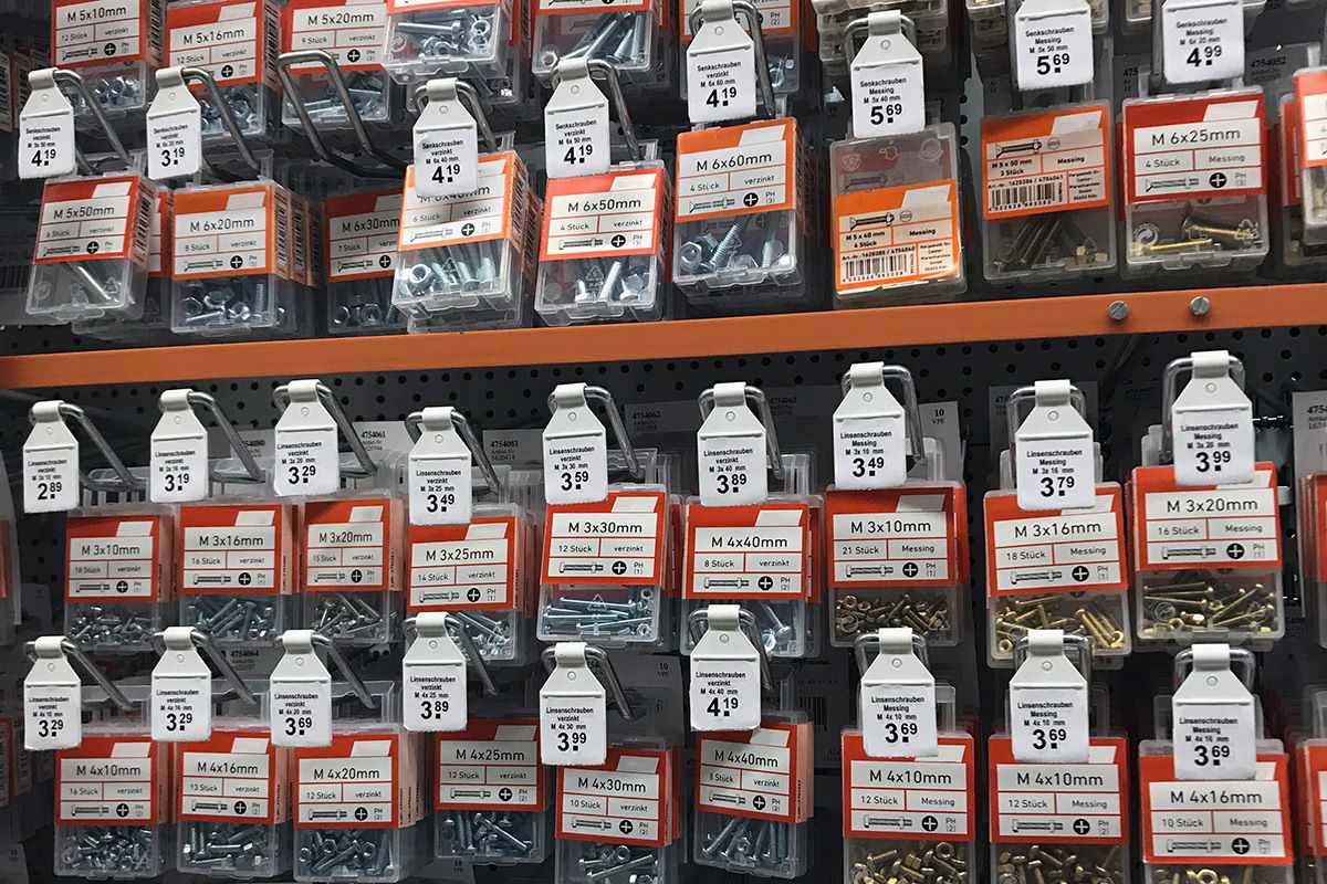 Solutions secteur des matériaux de construction : crochets pliants avec étiquette en magasin de bricolage, vue en rayon.