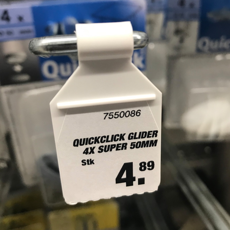 Solutions secteur des matériaux de construction : crochets pliants avec étiquette en magasin de bricolage, côté avant.
