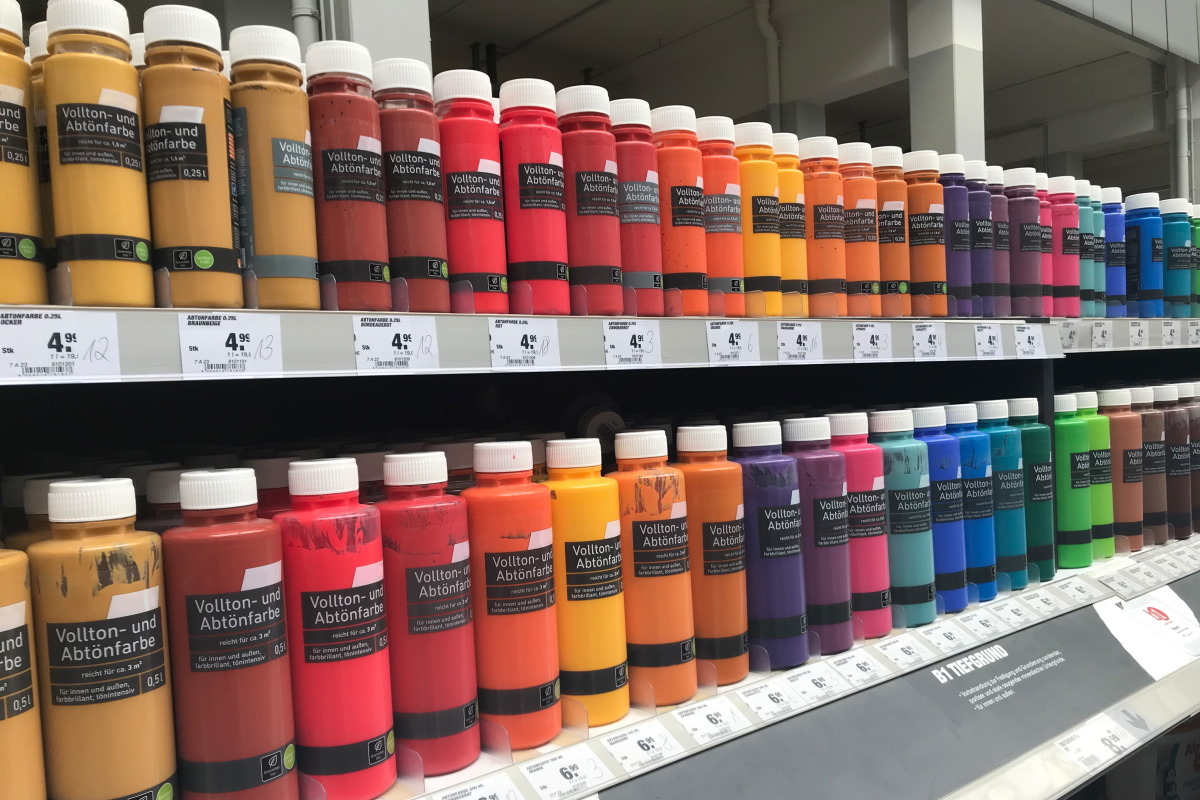 Solutions secteur des matériaux de construction : Étiquettes en impression numérique sur des bouteilles colorées dans les rayons des magasins de bricolage.