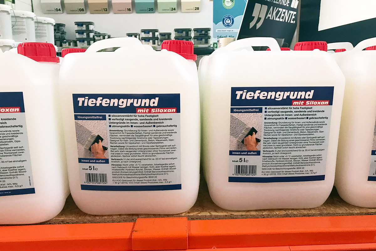 Solutions secteur des matériaux de construction : Étiquettes en impression numérique sur de grands bidons industriels dans les rayons des magasins de bricolage, motif primaire avec siloxane.