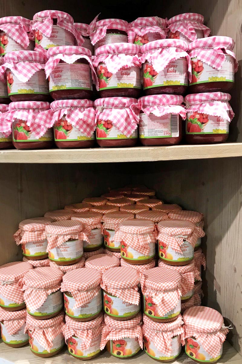 Commander des étiquettes en rouleau en impression numérique en ligne : étiquettes de confiture sur des bocaux de tartinade, de nombreux bocaux sur l'étagère.