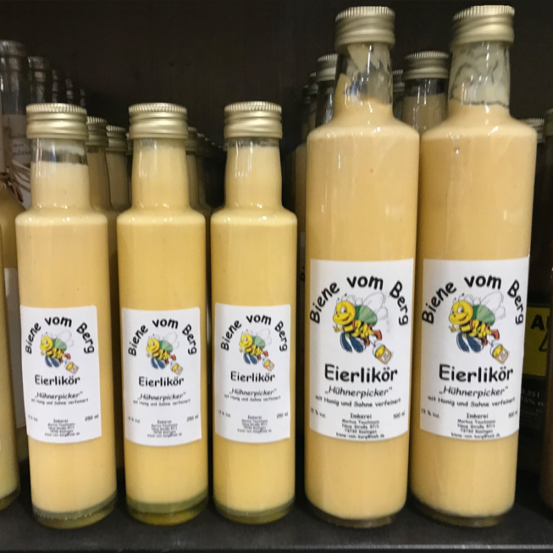 Commander des étiquettes en rouleau en impression numérique en ligne : Étiquettes de liqueur aux œufs sur des bouteilles dans l'étagère.