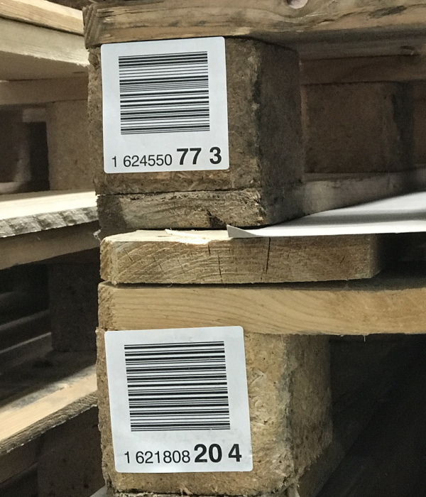 Étiquettes d'expédition et d palettes : Étiquettes de pied de palette avec impression de code-barres, sur des palettes en bois brut (socles de palette).