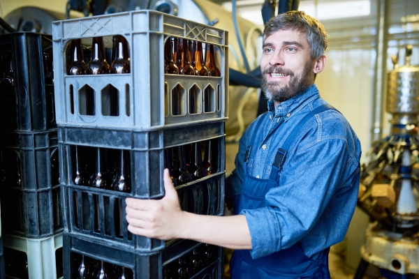 Employés avec des caisses de boissons dans l'industrie des boissons