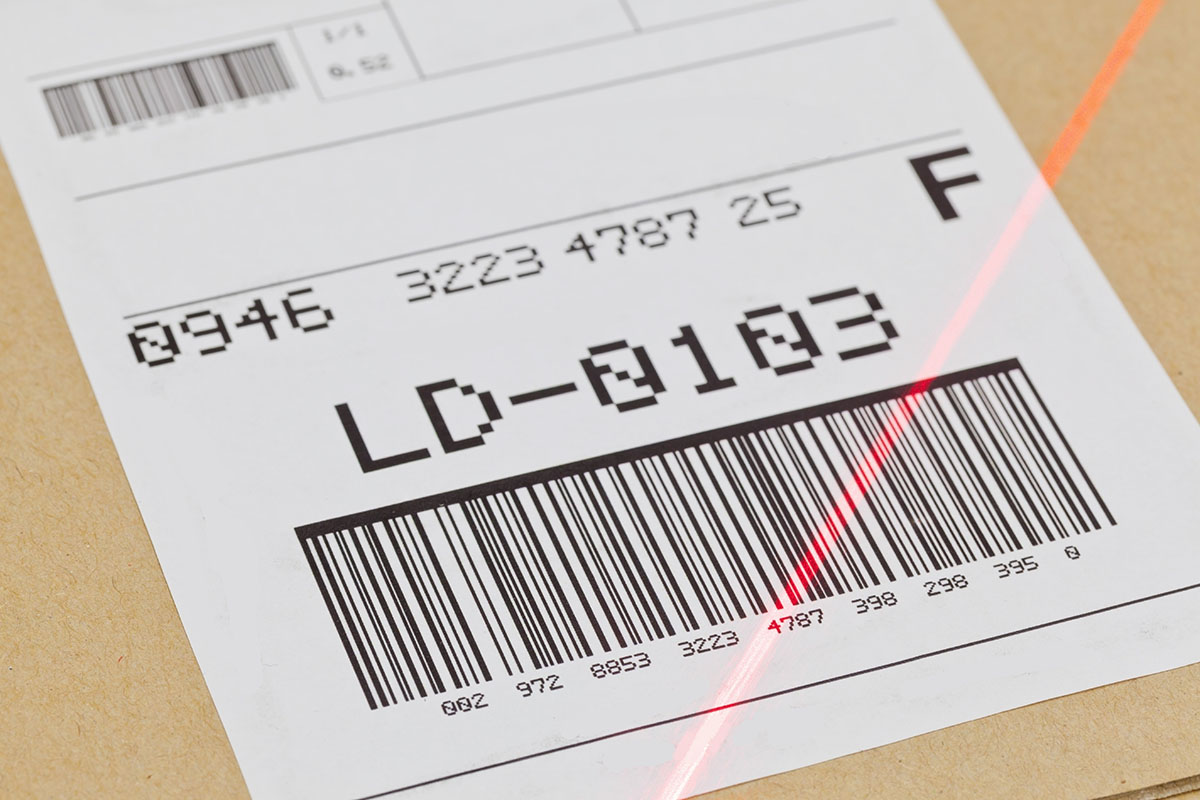 Étiquettes à codes-barres : Code-barres sur l'étiquette d'expédition avec ligne de scanner rouge.