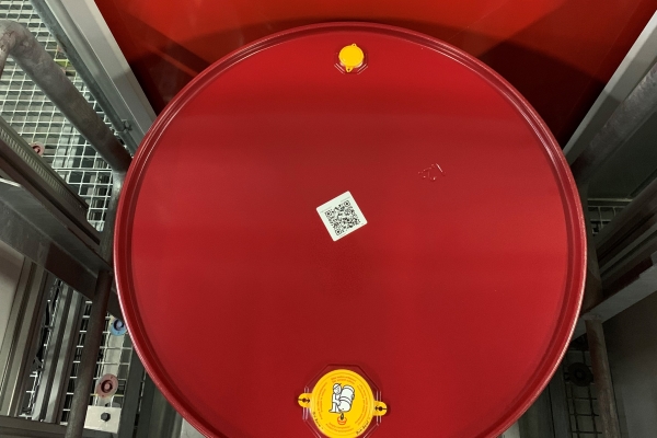 Étiquettes de substances dangereuses et de marchandises dangereuses : Étiquette de conteneur BASF avec code-barres, sur un fût en acier rouge.