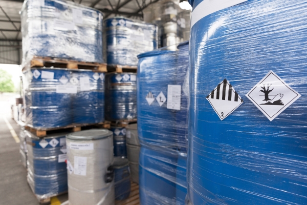 Étiquettes de substances dangereuses et de marchandises dangereuses : Étiquettes de marchandises dangereuses sur des conteneurs shrinkés dans le secteur chimique.