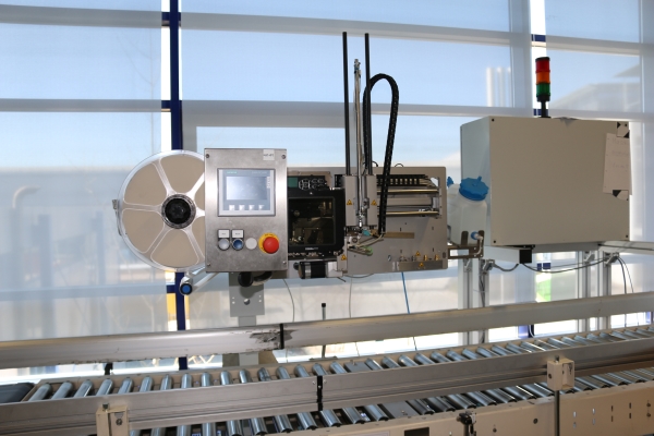 HERMA InNo-Liner : Machine à étiqueter HERMA InNo-Liner devant une vitrine en verre