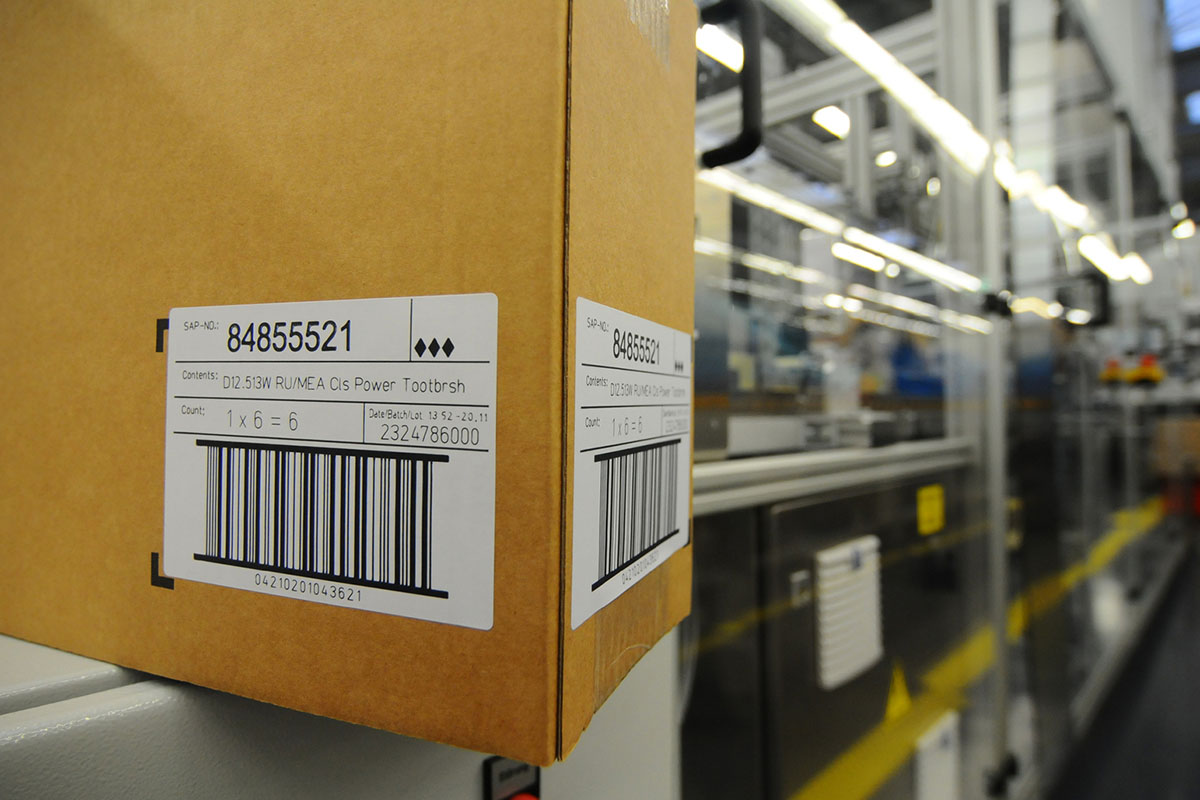 Étiquettes activables au laser : étiquette d'expédition sur carton brun dans la logistique.