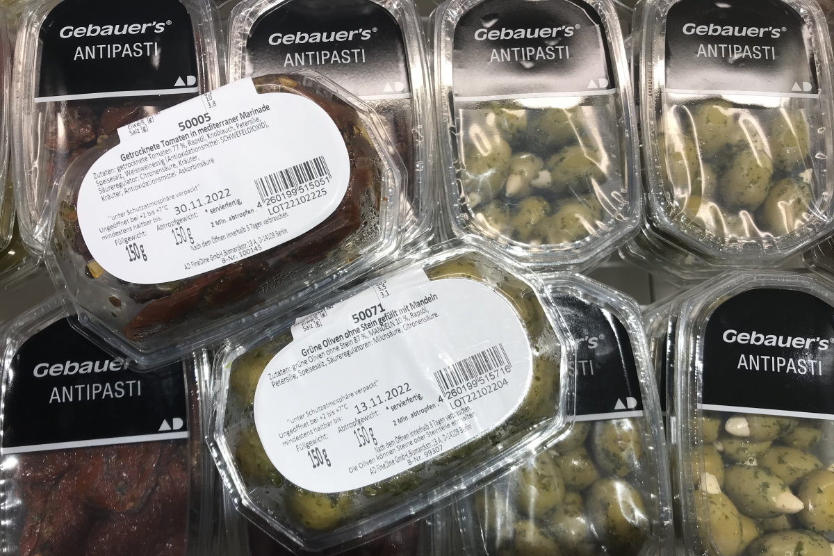 Étiquettes durables : Étiquettes à décollement sur des emballages en clamshell avec antipasti.