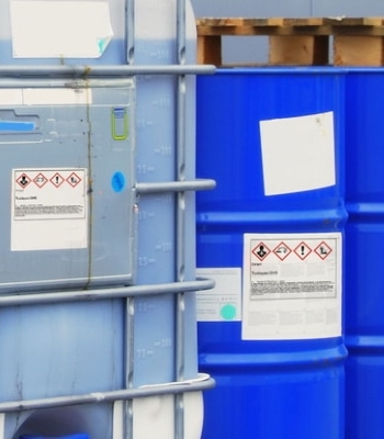 Étiquettes de substances dangereuses et de marchandises dangereuses : Étiquettes de substances dangereuses sur les contenants chimiques en extérieur.