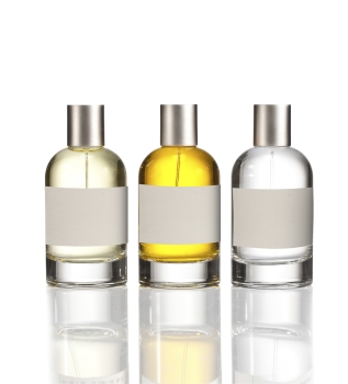 Trois bouteilles en verre contenant des liquides différents : une claire, une jaune et une vert clair. Toutes ont un bouchon argenté et une étiquette vierge.