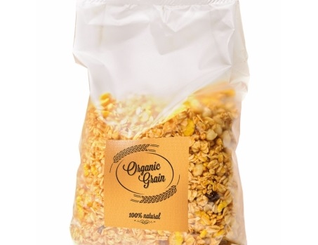 Un sac transparent de muesli, étiqueté "Céréales biologiques" et "100% naturel". Le mélange contient différentes sortes de céréales et des fruits secs.