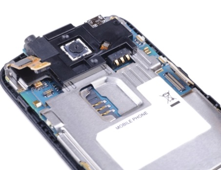 Composants internes d'un téléphone mobile, y compris la caméra, le slot pour carte SIM et la carte mère.