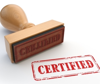 Un tampon en bois avec l'inscription "CERTIFIÉ" en rouge, à côté d'une empreinte rouge du mot "CERTIFIÉ".