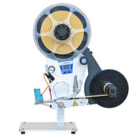 Une étiqueteuse avec une grande bobine et un ruban noir, équipée d'un panneau de commande et d'une base stable.