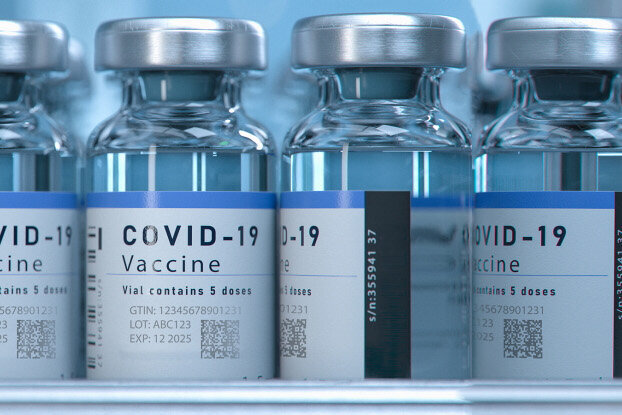 Étiquettes laser UV : Étiquettes de marquage sur des flacons de vaccin dans une ligne de conditionnement, vue de face, format paysage.