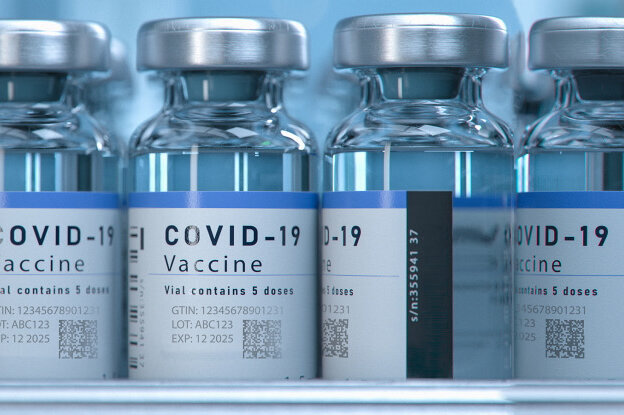 Étiquettes laser UV : Étiquettes de marquage sur des flacons de vaccin dans une ligne de conditionnement, vue de face, format paysage.