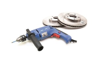 Un perceuse bleue est posée à côté de deux disques de frein. La perceuse a une poignée et une pointe rotative pour différentes applications.
