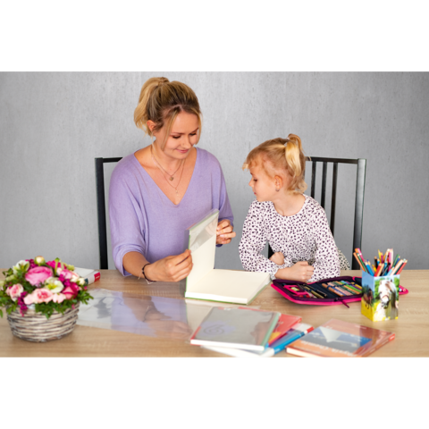 Eine Frau und ein kleines Mädchen sitzen an einem Tisch, während sie gemeinsam an einem Kunstprojekt arbeiten. Bunte Stifte und ein Blumenarrangement sind sichtbar.