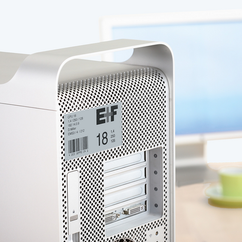 Silberner Computer-Tower mit Belüftungsgitter und technischen Spezifikationen auf einem Aufkleber.