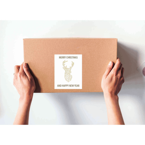 Braune Geschenkbox mit einem Aufkleber, der "Frohe Weihnachten und ein glückliches neues Jahr" sowie ein Rentiermotiv zeigt.