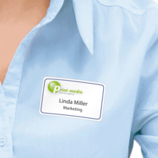 Namensschild auf einer blauen Bluse mit dem Text "Linda Miller, Marketing" und dem Logo einer Druckdienstleistungsagentur.