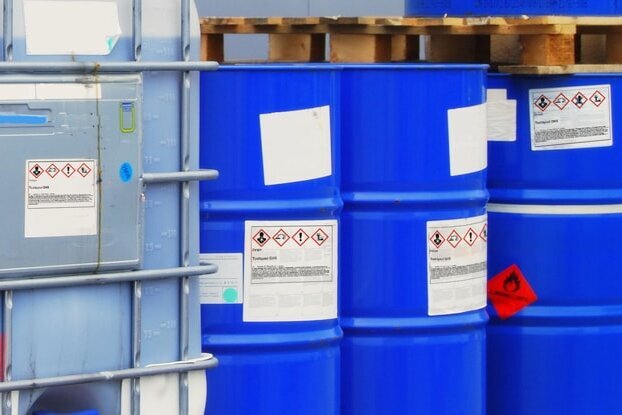 Étiquettes de marchandises dangereuses HERMA sur des fûts en acier bleus et des Bigpacks, format paysage