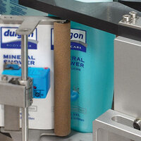 Des bouteilles de gel douche minéral sur une étagère, avec une étiquette bleue et un support gris.