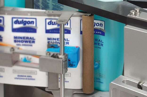 Une bouteille de "Dulgon Mineral Shower" se trouve sur une ligne de production, entourée d'autres bouteilles du même produit.