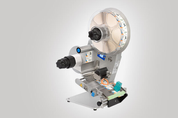 Une machine étiqueteuse industrielle avec un grand mécanisme à rouleaux et plusieurs commandes pour l'ajustement.