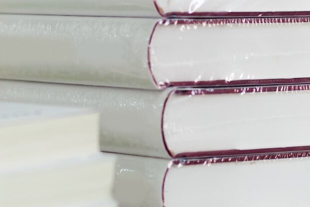 Text: "Livres sous film plastique, en pile, motif d'image pour l'étiquetage de livres avec des étiquettes détachables de HERMA, format paysage.
