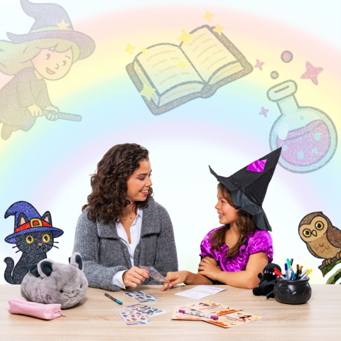 Une femme et une fille en costumes de sorcières sont assises à une table, entourées de matériel de bricolage et d'illustrations magiques.